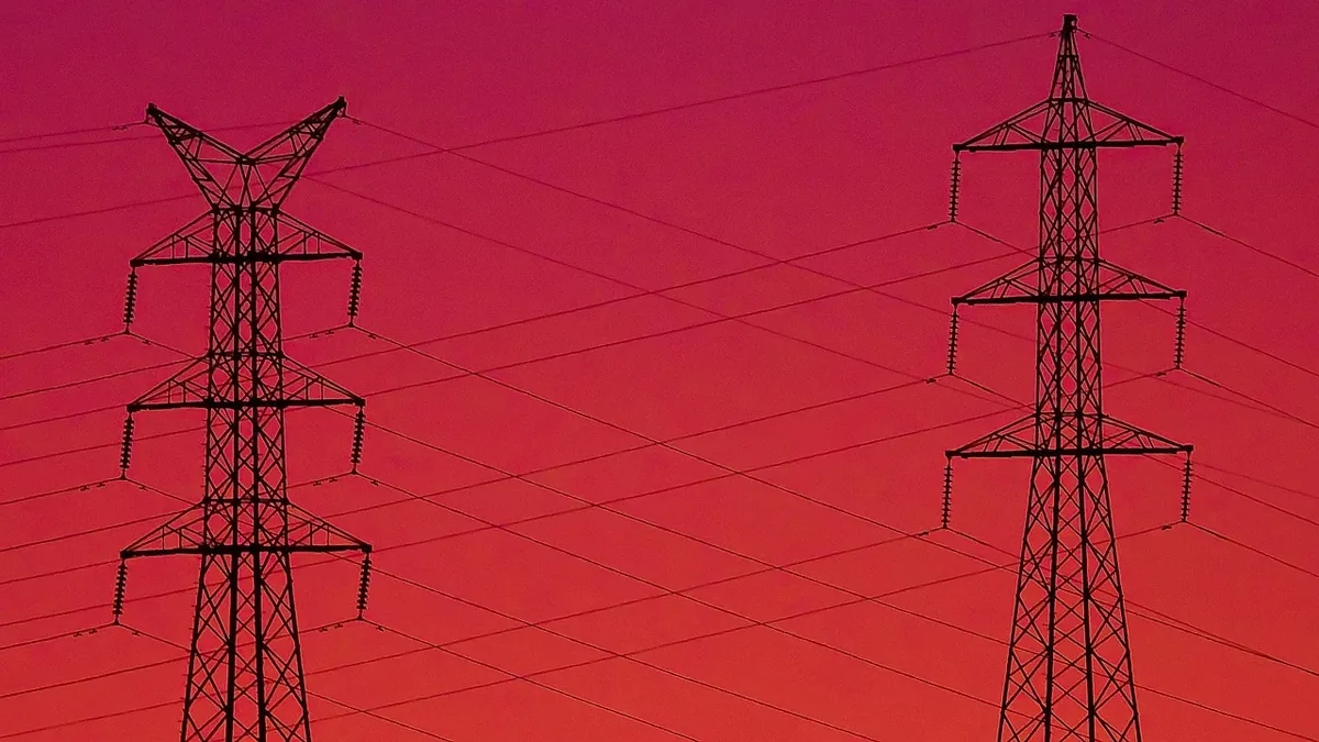 Two electrical towers with wires running between them.