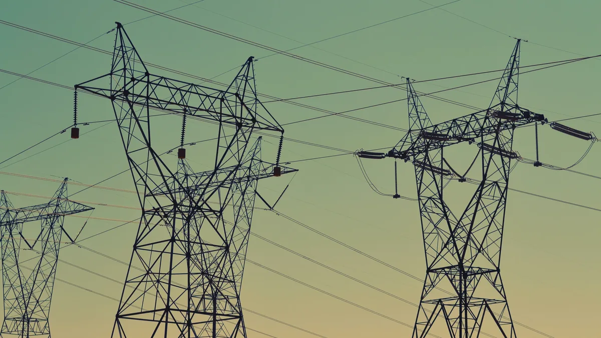 A group of power transmission towers, with multiple power lines suspended between them.