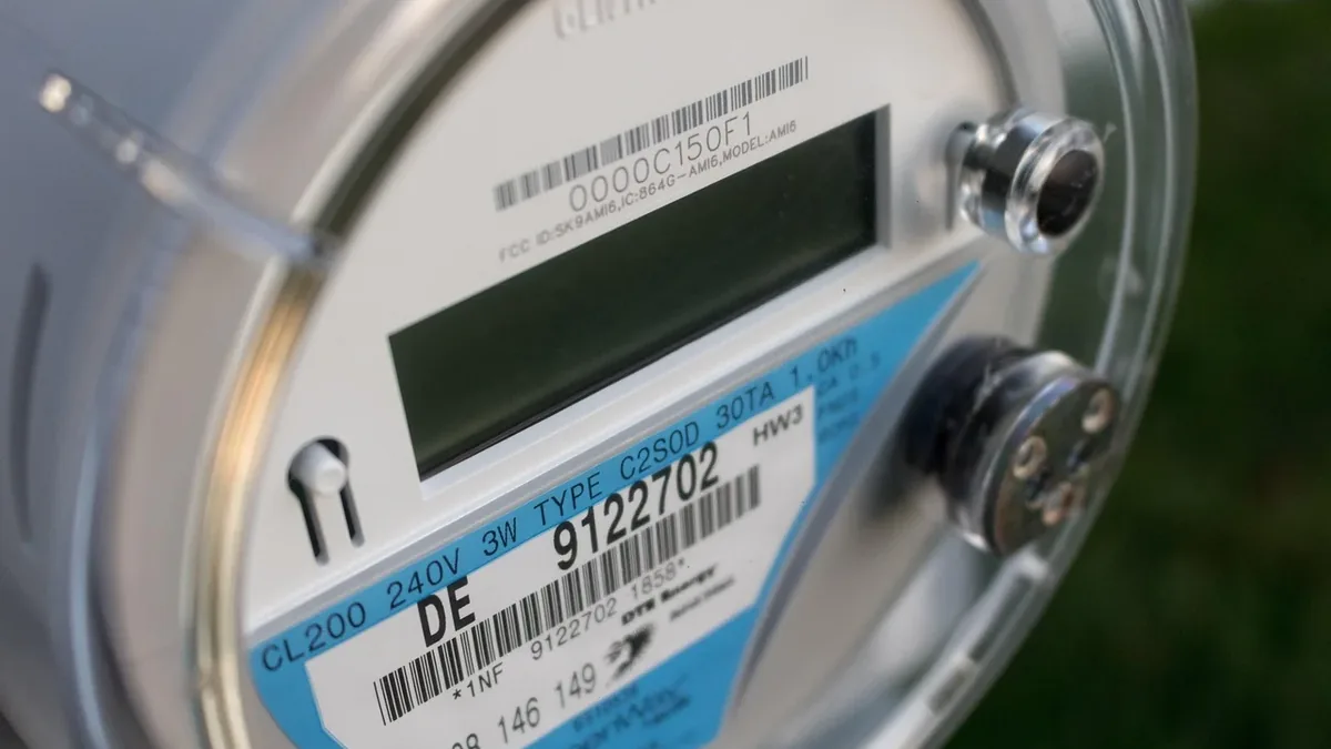 A close-up view of an electric meter with a digital display and a barcode label.