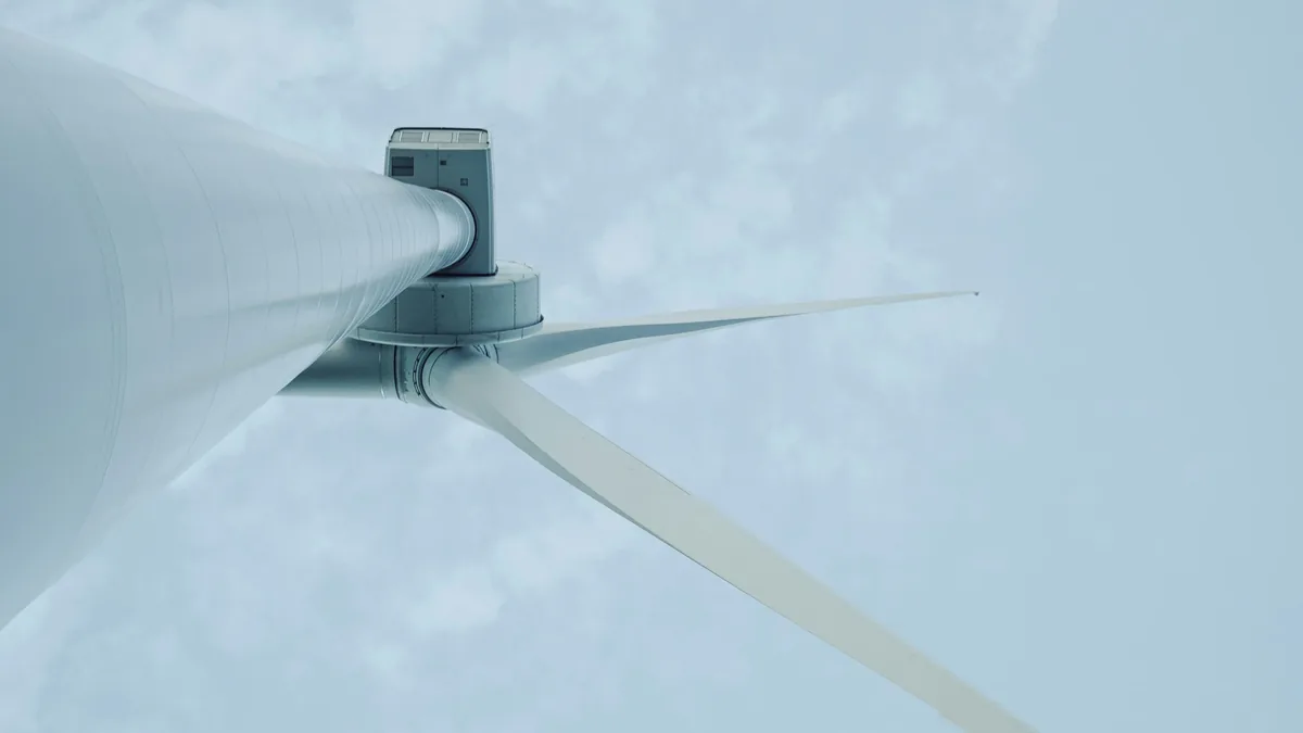 A wind turbine blade and hub, with the blade extending from the hub at an angle.